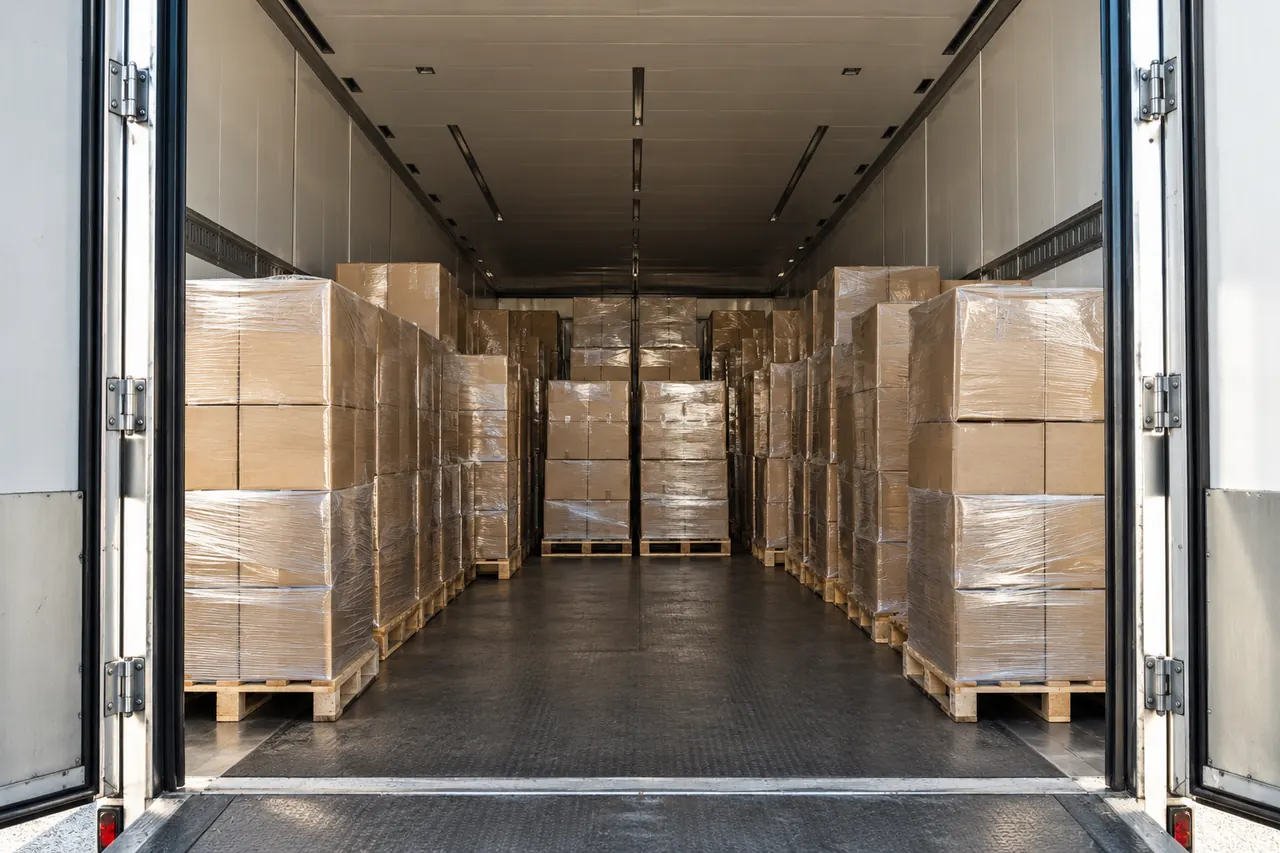 Semirremolque con las puertas abiertas y los palets cargados hasta el fondo.